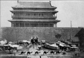 A caravan of camels passing in front of a Beijing city gate.  It was said that some five thousand camels came into Beijing every day.