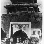 Communist soldiers walking below Kuomintang slogans on one of the city gates which survived the siege of Jinzhou, 1948.