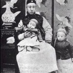 On her death-bed in 1908, Cixi made her two-year-old great-nephew, Puyi (standing), the next emperor, and his father, Zaifeng (seated holding Puyi's brother), the Regent.